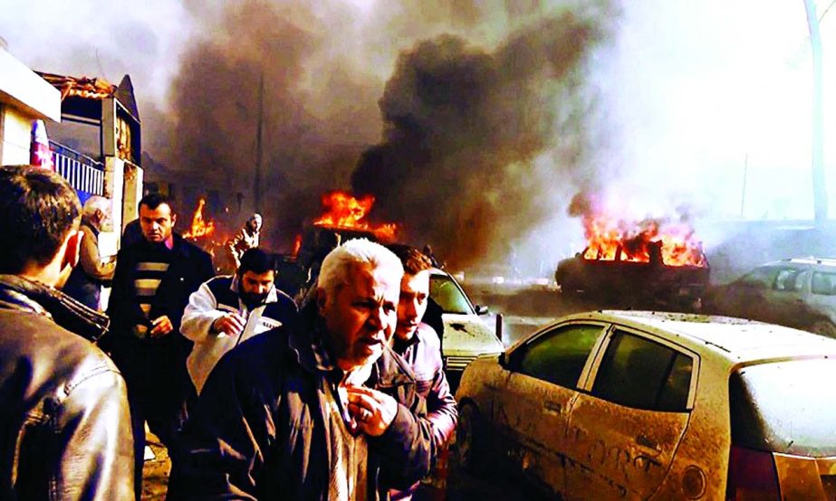 An image grab taken from an AFPTV video released on Saturday shows people gathering amidst the debris at the site of a car bomb attack in Syria.