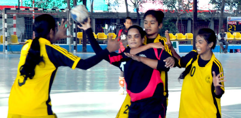 A scene from the match of the EXIM Bank 27th National Women's Handball Championship between BJMC and Madaripur district team at the Shaheed (Captain) M Mansur Ali National Handball Stadium on Monday.