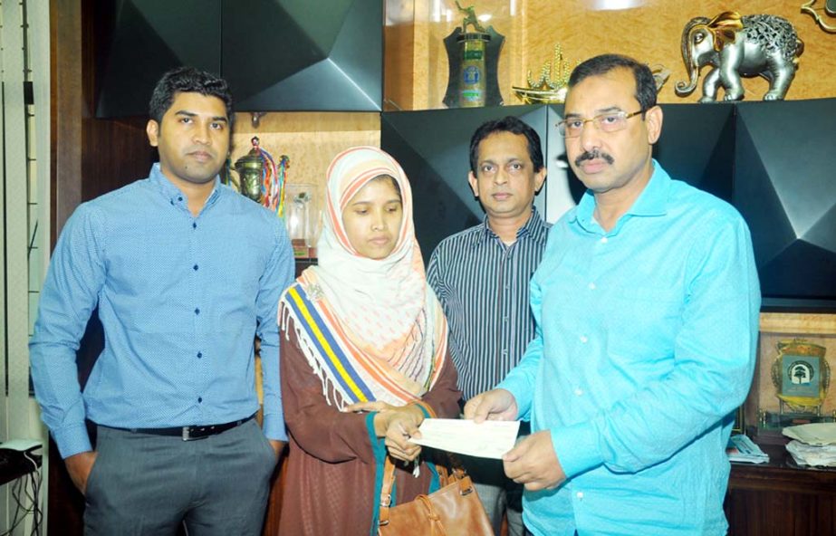 CCC Mayor AJM Nasir Uddin handing over a cheque as donation to the wife of late Dr Azharul Islam, a medical officer of the City Corporation at CCC office on Wednesday afternoon.