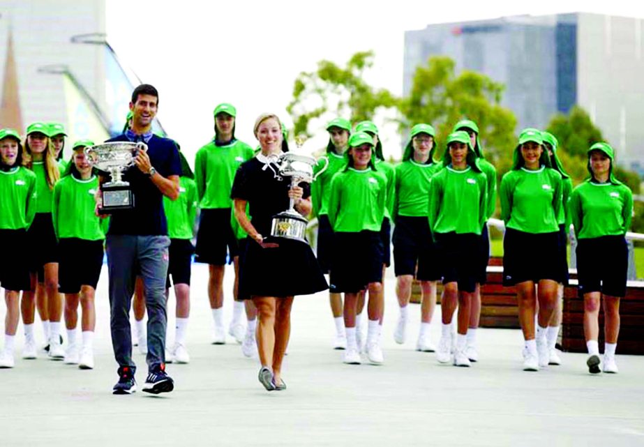 Defending men's and woman's champions Serbia's Novak Djokovic (left) and Germany's Angelique Kerber carry their trophies to the official draw ceremony ahead of the Australian Open tennis championships in Melbourne, Australia on Friday.