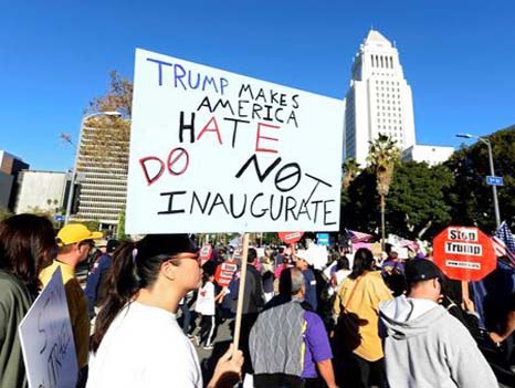 Protesters hold up signs during a march and rally against the United States President-elect Donald Trump in Los Angeles, California.