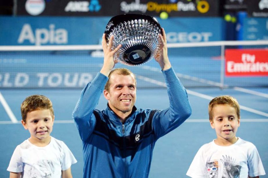 Gilles Muller of Luxembourg holds up his trophy after beating Daniel Evans of Britain in the men's singles final match at the Sydney International tournament on Saturday.