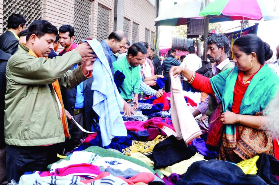 Buyers crowd the makeshift market to buy winter clothes. The snap was taken from the city's Motijheel on Sunday.