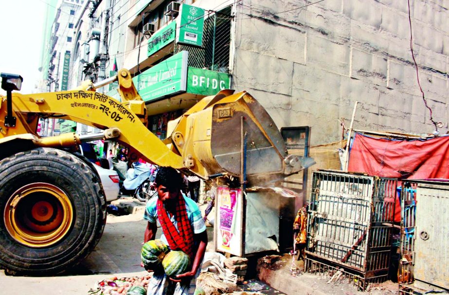 Illegal establishments being bulldozed by Dhaka South City Corporation at Motijheel area on Sunday.