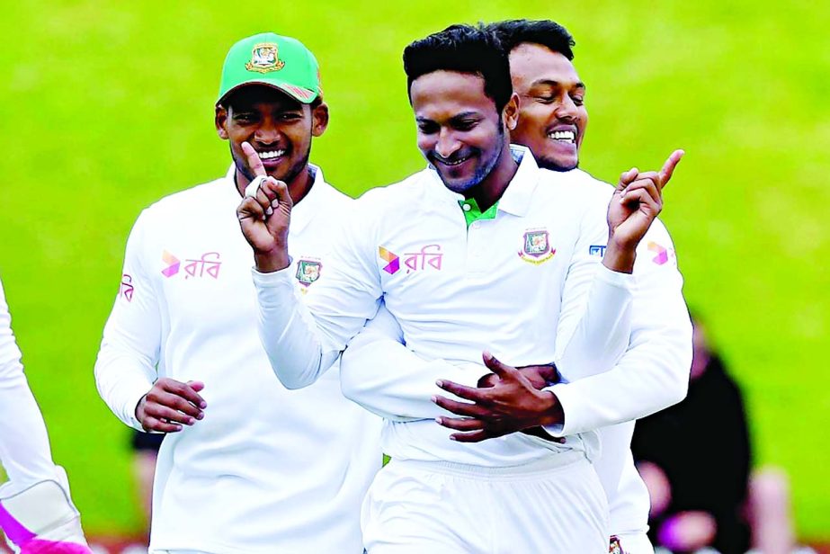 Shakib Al Hasan (C) celebrates New Zealand's Tom Latham being caught with LBW with teammates Kamrul Islam Rabbi (R) and Nazmul Hossain Shanto (L) during day four of the first international Test cricket match between New Zealand and Bangladesh at the Basi