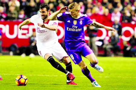 Real Madrid's Toni Kroos, right, and Sevilla's Vicente Iborra challenge for the ball during La Liga soccer match between Real Madrid and Sevilla at the Ramon Sanchez Pizjuan stadium, in Seville, Spain on Sunday.