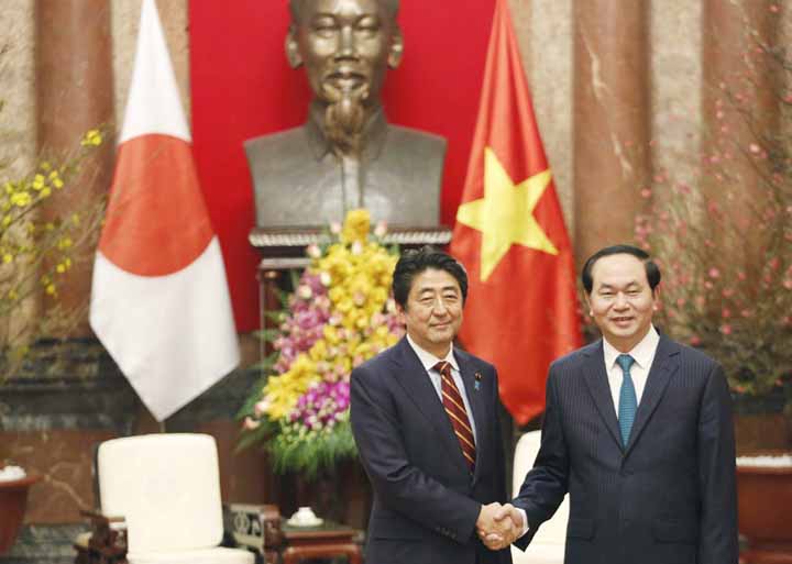 Vietnam's President Tran Dai Quang, right, and Japanese Prime Minister Shinzo Abe shake hands at the Presidential Palace in Hanoi, Vietnam on Monday.