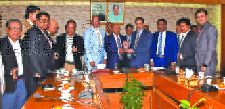 Abul Kasem Khan, President of Dhaka Chamber of Commerce & Industry (DCCI) along with newly elected Board of Directors of DCCI handing over a crest to the Commerce Minister Tofail Ahmed, MP at his secretariat office on Tuesday. Hedayetullah Al Mamoon, ndc,