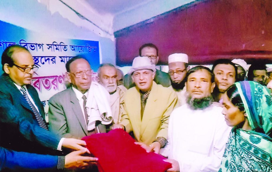 Justice FRM Nazmul Ahsan distributing blankets among the destitute at a function organised by Barisal Bibhag Samity in the city's Motijheel area on Friday.