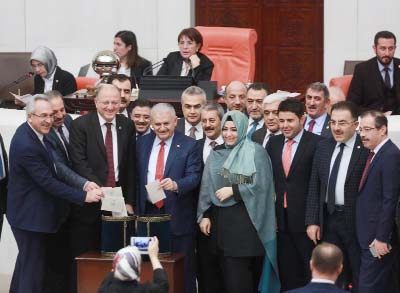 Turkey's Prime Minister Binali Yildirim Â© accompanied by lawmakers votes following a parliament debate on proposed amendments to the country's constitution.