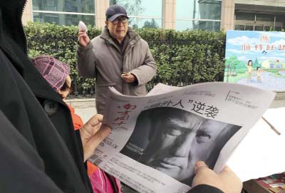 A Chinese man holds up a Chinese newspaper with the front page photo of U.S. President-elect Donald Trump and the headline "Outsider counter attack" at a newsstand in Beijing, China.