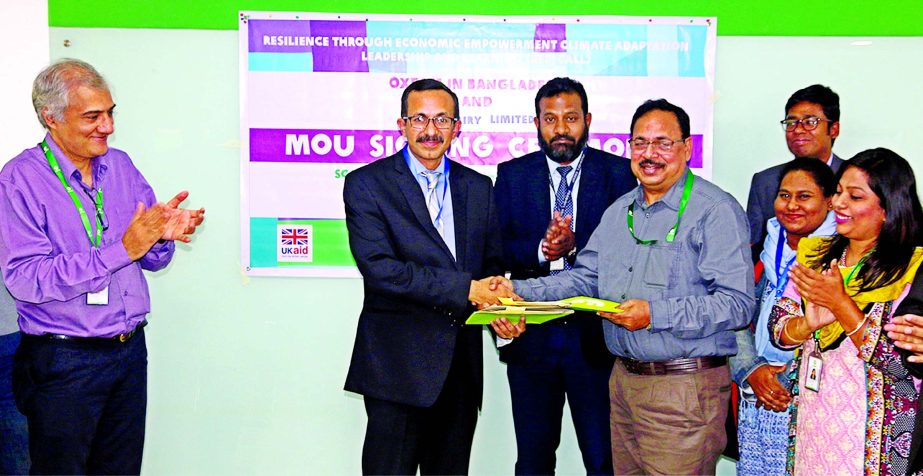 Md Muniruzzaman, Chief Operating Officer of PRAN Dairy Limited and MB Akhter, Programme Director of Oxfam Bangladesh exchanging documents after signing a MoU in the city recently. Snehal V Soneji, Country Director of Oxfam Bangladesh, Rajib Ibne Islam, G