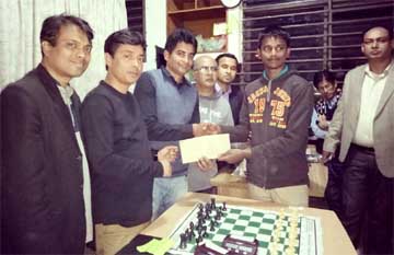 Subrata Biswas (second from right), the champion of the Week End Rapid Chess Tournament receiving the prize-money from Mostafa Haider, the founder of Uttara Public Library, at Uttara Education Garden School & College in Uttara on Saturday. Uttara Central