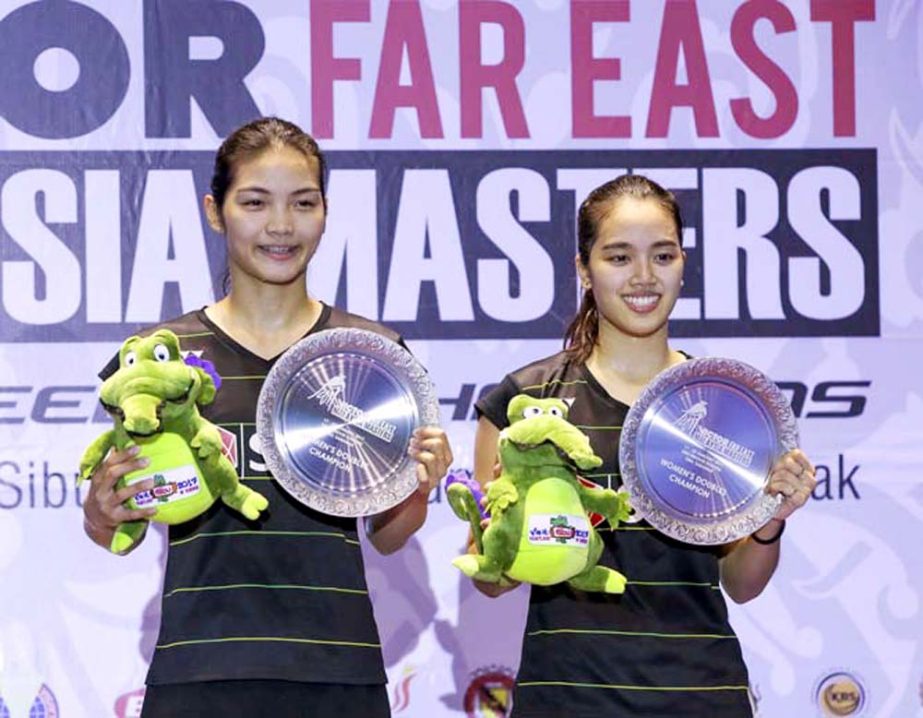 Thailand's Kititharak Jongkolpha (left) and Rawinda Prajongjai pose with their trophies after defeating Hong Kong pair Ying Suet and Poon Lok Yan in their women's doubles final match at the Malaysia Masters badminton tournament in Sibu, Sarawak, Malaysi