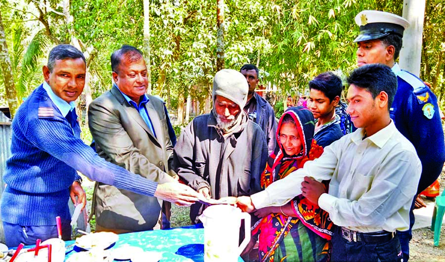 Squadron leader of Birshreshtha Matiur Rahman Base of Air Force, Jessore Cantonment Harun-or-Rashid handing over appointment letter to the Prime Minister's van driver Imam Sheikh for a job in the Air Force at his Sardarpara village home in Tungipara on S