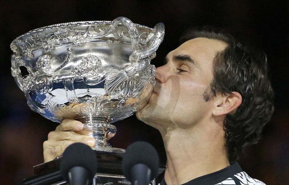 Roger Federer lifts the Australian Open trophy for the fifth time in his career after beating Rafael Nadal across five sets on Sunday.