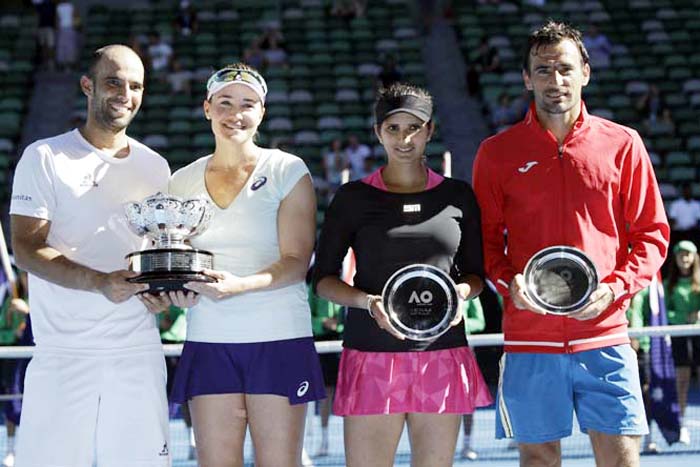 Abigail Speers of the US and Juan Sebastian Cabal (left) of Colombia hold their trophy after defeating India's Sania Mirza (second right) and Ivan Dodig (right) in the mixed doubles' final at the Australian Open tennis championships in Melbourne, Austra
