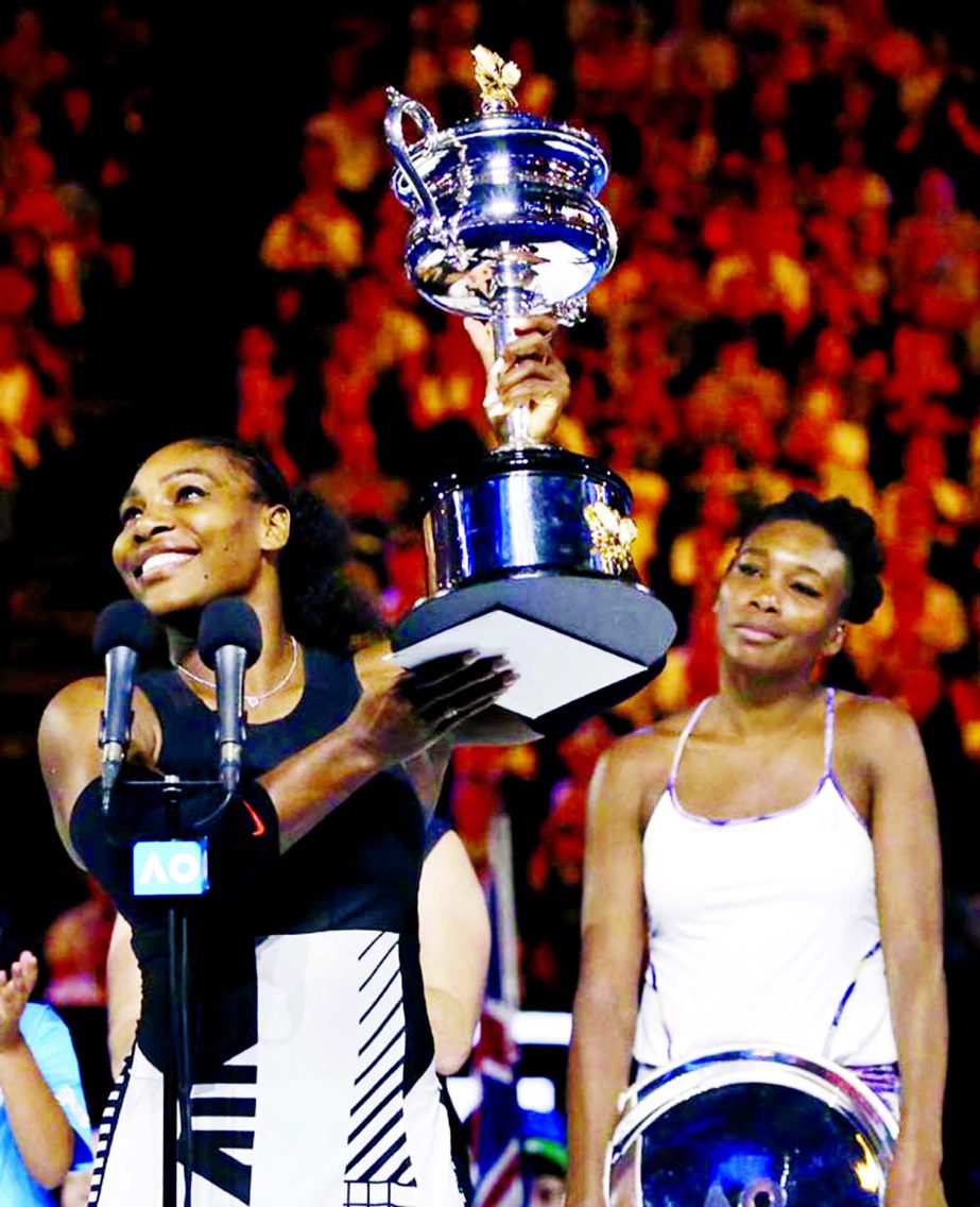 United States' Serena Williams (left) holds her trophy after defeating her sister Venus during the women's singles final at the Australian Open tennis championships in Melbourne, Australia on Saturday.