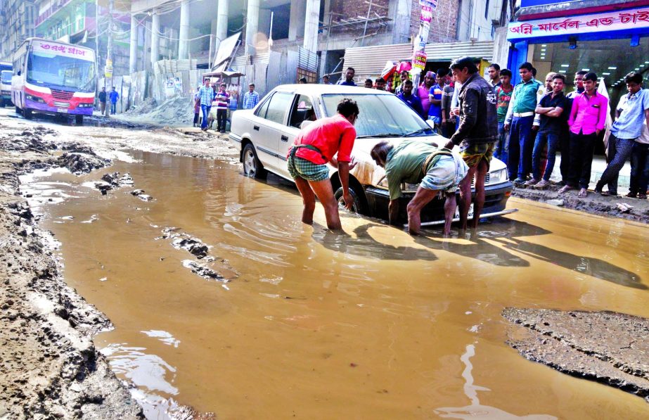 A car was trapped inside the ditch developed near Malibagh Rail gate adjacent to the under construction flyover on Monday. Though this has become a regular feature, the authorities concerned do not pay any heed to overcome the problem.