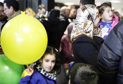 Sima, a 7-year-old Syrian refugee from Homs, plays with a balloon as her mother M'aha Aleweir holds her 3-year old sister Sidra upon their arrival at Rome's Fiumicino international airport on Monday..