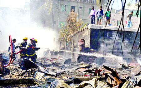 A devastating fire broke out at Chaktai Shutki Godown engulfing other houses adjacent to Godown in Chittagong on Sunday. Firefighters trying to douse the flame.