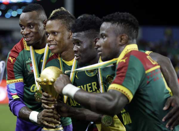 Cameroon players pose with the trophy after winning the African Cup of Nations final soccer match between Egypt and Cameroon at the Stade de l'Amitie in Libreville, Gabon on Sunday. Cameroon won 2-1.