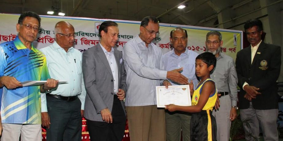 Deputy-Secretary General of Bangladesh Olympic Association Ashiqur Rahman Miku giving away a certificate to a tiny gymnast as the special guest at the gymnasium of National Sports Council on Tuesday.