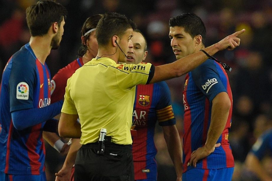 The referee shows the red card to Barcelona's Uruguayan forward Luis Suarez (R) during the Spanish Copa del Rey semi final second leg football match FC Barcelona vs Club Atletico de Madrid at the Camp Nou stadium in Barcelona on Wednesday.