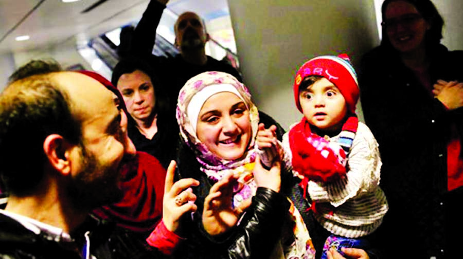 Syrian refugee Baraa Haj Khalaf holds her daughter as she greets people at O'Hare International Airport with her husband Abdulmajeed (L) on Tuesday in Chicago, Illinois.