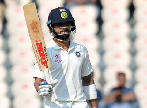 Virat Kohli raises his bat after reaching fifty during the first day of the Test match against Bangladesh in Hyderabad, India on Thursday.