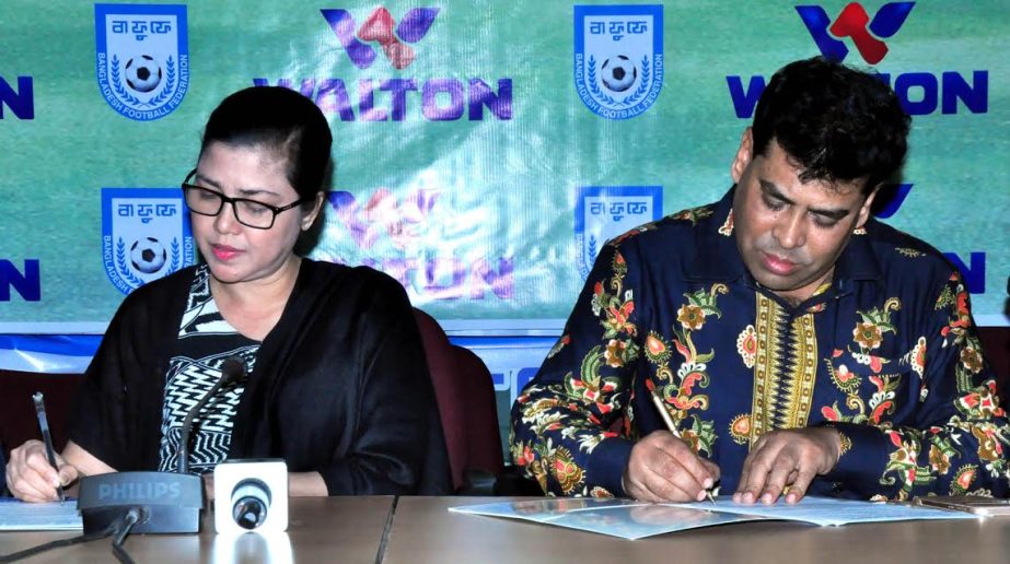 Chairperson of the Women's Wing of BFF Mahfuza Akter Kiron and Head of Sports and Welfare Department of Walton Group FM Iqbal Bin Anwar Dawn signing their respective agreement papers at the conference room of BFF House on Sunday.