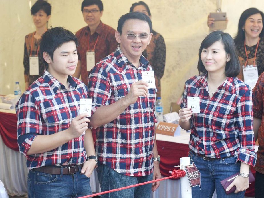 Jakarta's Christian governor Basuki Tjahaja Purnama Â©, better known as "Ahok", flanked by his wife Veronica Â® and son Nicholas (L) show off their ballot papers in Jakarta on Wednesday.