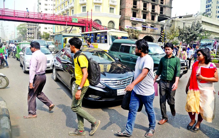 People of all walks of life passing the main busy thoroughfare taking the life risk ignoring the BRTA authorities frequent action and avoiding the adjacent foot-over bridge. This photo was taken from Bangla Motor area on Wednesday.