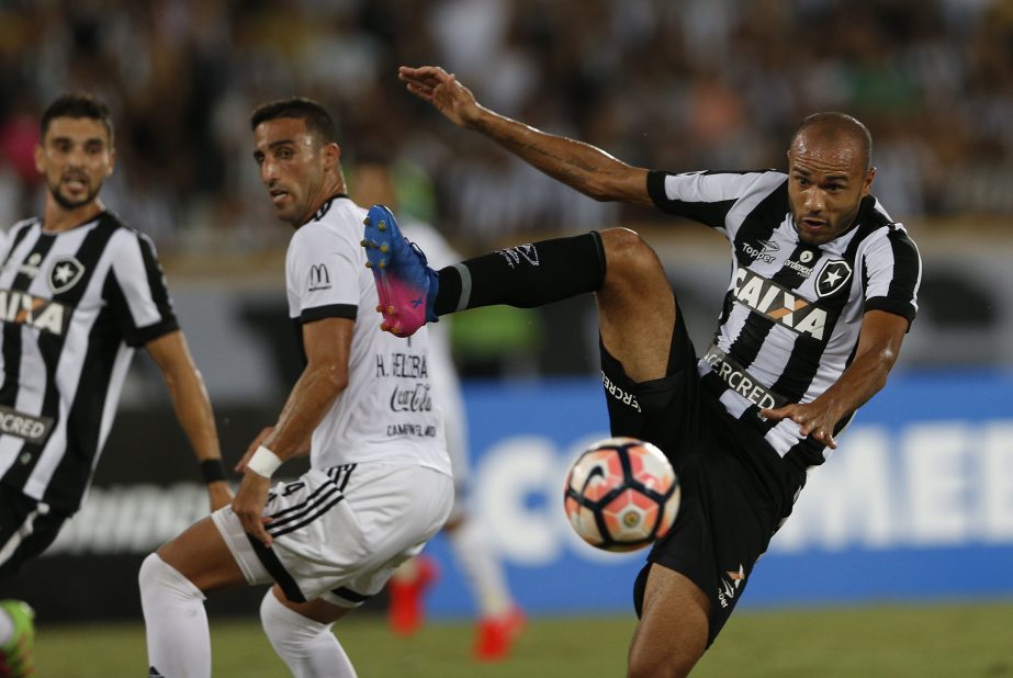 Roger of Brazil's Botafogo (right) tries to kick the ball to score against Paraguay's Olimpia during a Copa Libertadores soccer match at the Nilton Santos stadium, in Rio de Janeiro, Brazil on Wednesday.
