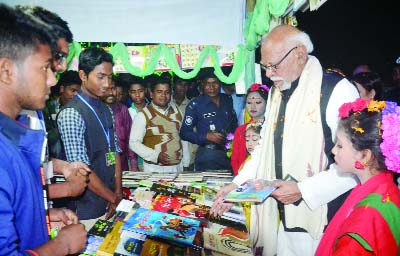 NATORE: Land Minister Shamsur Rahman Sharif MP visiting a book stall at Ekushey Book Fair at Rajapur High School premises in Baraigram Upazila on Sunday.