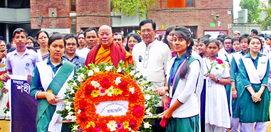 Founder Chairman of Banophool Adibashi Green Heart College Ven. Prajnananda Mahathera along with others placing floral wreaths at the college Shaheed Minar in the city on Tuesday in observance of Amar Ekushey.