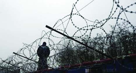 A Hungarian police officer stands guard at Serbia's border with Hungary near a makeshift camp for migrants in Horgos, Serbia.