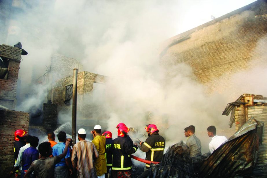 Fire fighters making frantic efforts to extinguish fire in the city's Islambag area on Saturday.