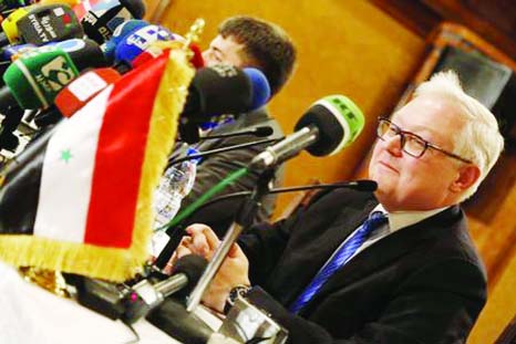 Russia's Deputy Foreign Minister Sergei Ryabkov sits near the Syrian national flag as he addresses a news conference in Damascus.