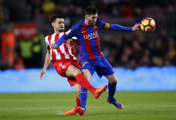 FC Barcelona's Lionel Messi (right) duels for the ball against Sporting Gijon's Sergio Alvarez during the Spanish La Liga soccer match between FC Barcelona and Sporting Gijon at the Camp Nou stadium in Barcelona, Spain on Wednesday.