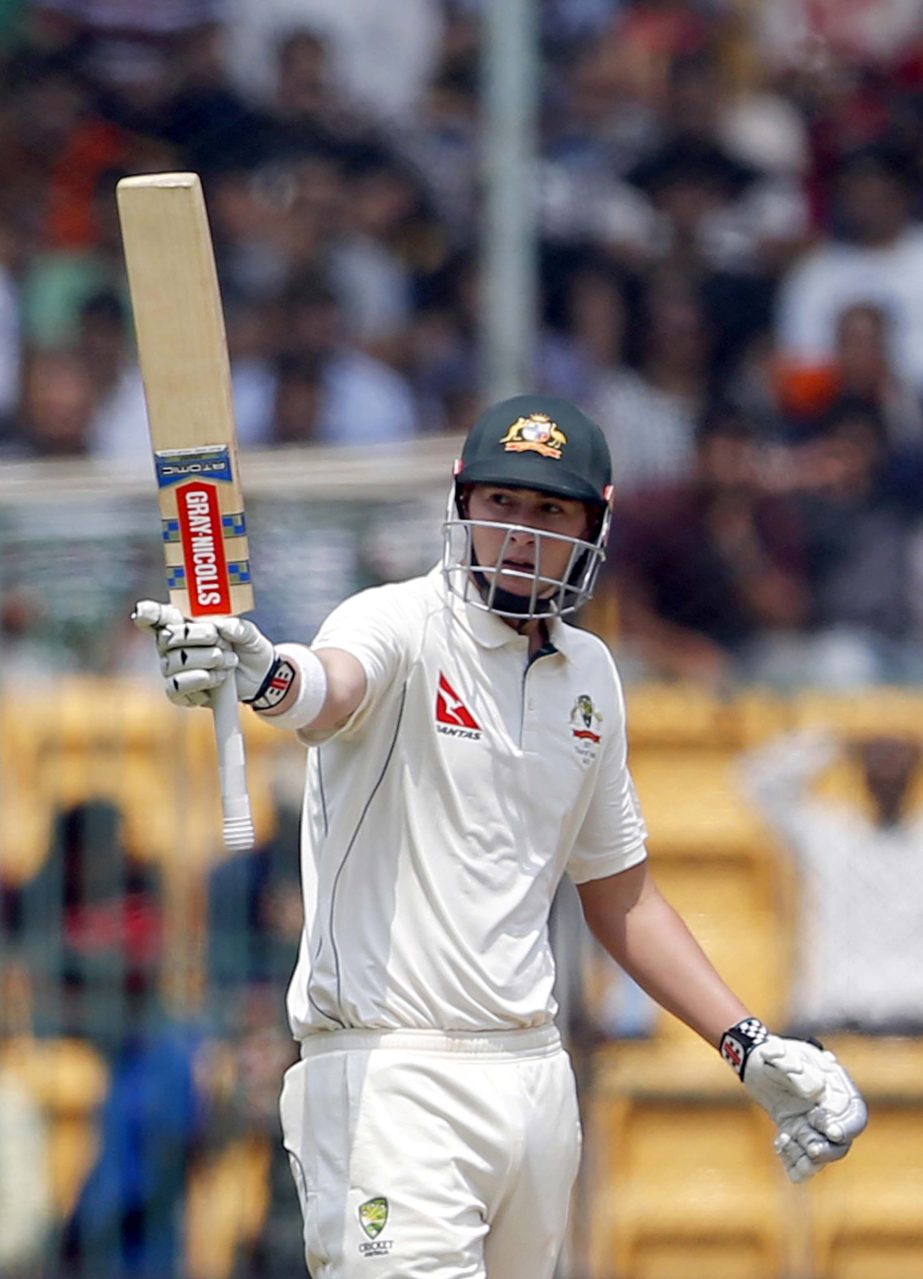 Australia's Matt Renshaw raises his bat to celebrate scoring fifty runs during the second day of their second Test cricket match against India in Bangalore, India on Sunday.