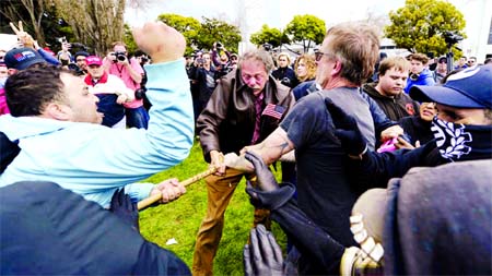 Anti-Trump protesters try to take a large piece of wood away from a Trump supporter at a rally for President Donald Trump at Martin Luther King Jr. Civic Center Park in Berkeley, Calif., Saturday. Internet photo