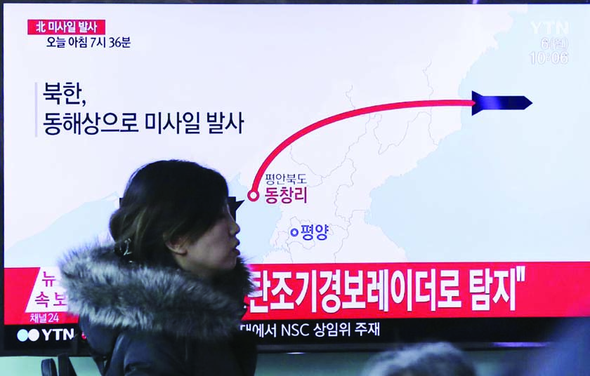 A visitor walks by the TV screen showing a news program reporting about North Korea's missile firing, at Seoul Train Station in Seoul, South Korea on Monday.