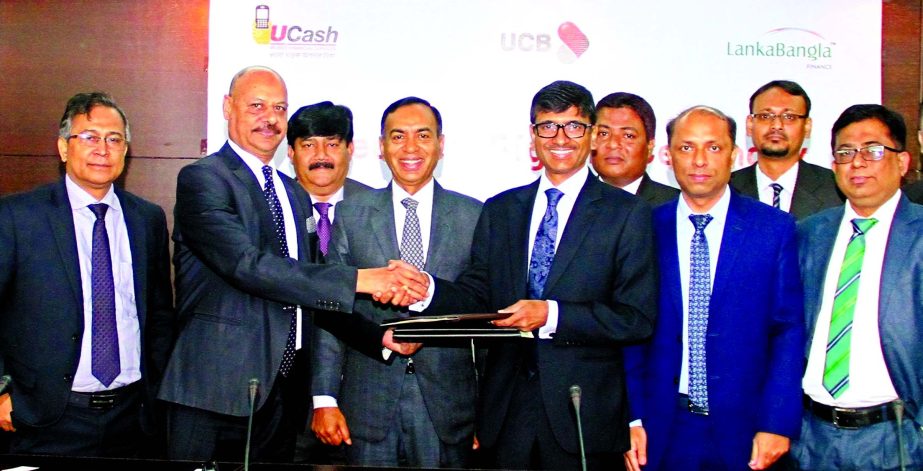 Mirza Mahmud Rafiqur Rahman, Additional Managing Director of United United Commercial Bank Limited (UCB) and Khwaja Shahriar, Acting Managing Director of Lanka Bangla Finance Limited (LBFL), exchanging documents after signing an agreement at the banks hea