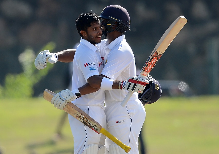 Kusal Mendis is congratulated by Asela Gunaratne after raising his century on the 1st day of 1st Test between Sri Lanka and Bangladesh at Galle on Tuesday.