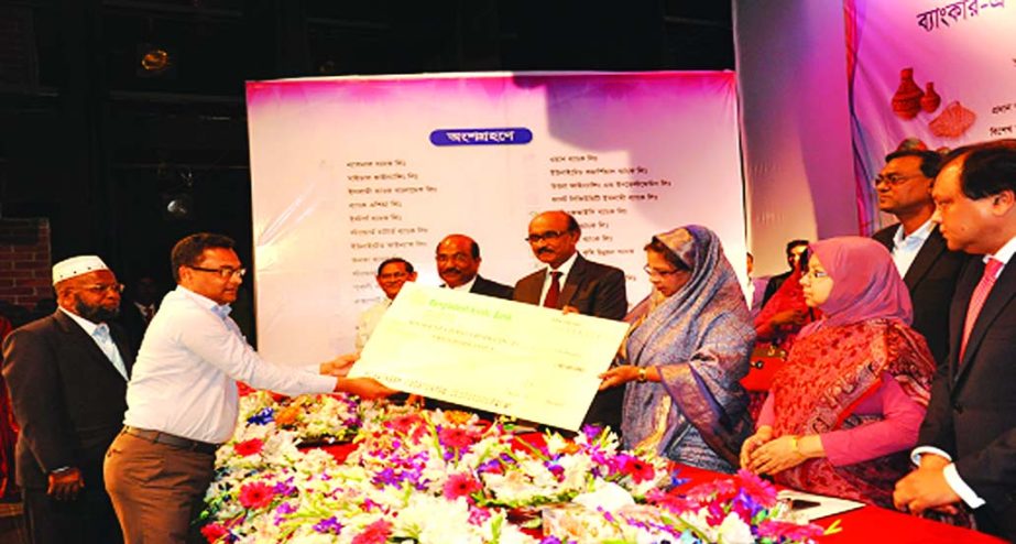 State Minister for Women and Children Affairs Meher Afroz Chumki MP, handing over a cheque to Mir Jamil Ali, Director of Saudia Food Products (Pvt) Ltd, in the "Banker SME Nari Uddogta Somabesh and Ponnya Prodorshoni Mela 2017" at a city auditorium rece