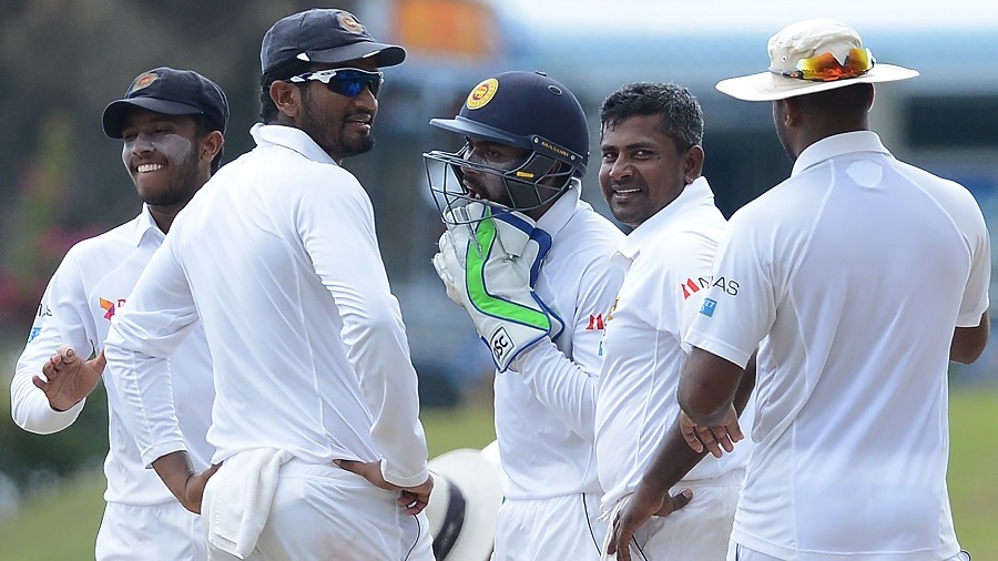 Sri Lankan spinner Rangan Herath (2R) celebrates with teammates after he dismissed his unseen Bangladesh counterpart Mushfiqur Rahim during the third day of the opening Test cricket match between Sri Lanka and Bangladesh at the Galle International Cricket