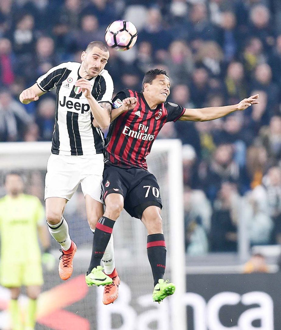 Juventus' Leonardo Bonucci (left) and Milan's Carlos Bacca vie for the ball during the Italian Serie A soccer match between Juventus and Milan at the Juventus stadium in Turin, Italy on Friday.