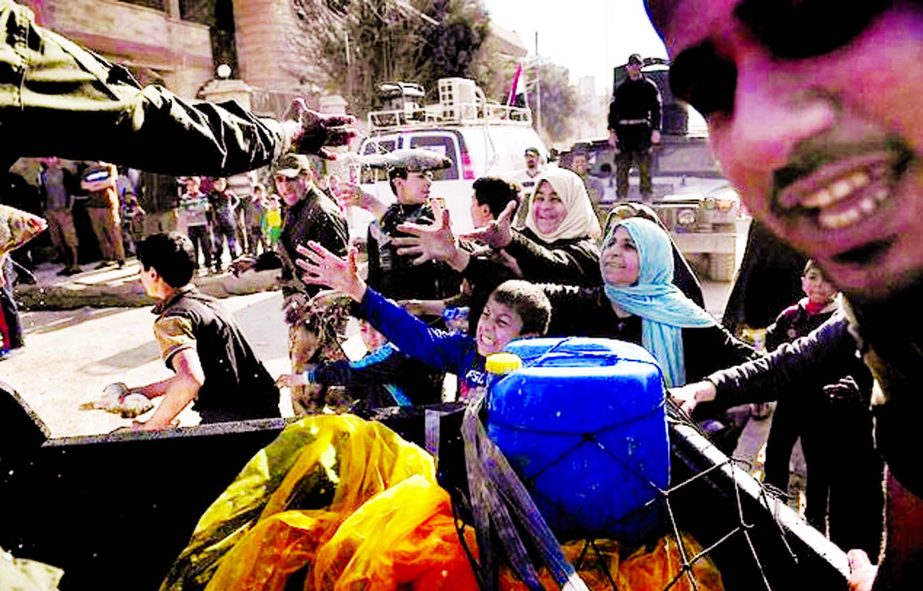 Iraqi troops distribute food aid to residents of west Mosul on March 10 as Iraqi forces advance in the city.