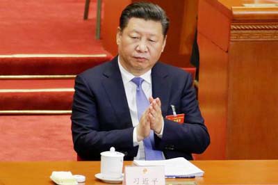 China's President Xi Jinping claps during the opening session of the National People's Congress (NPC) at the Great Hall of the People in Beijing.